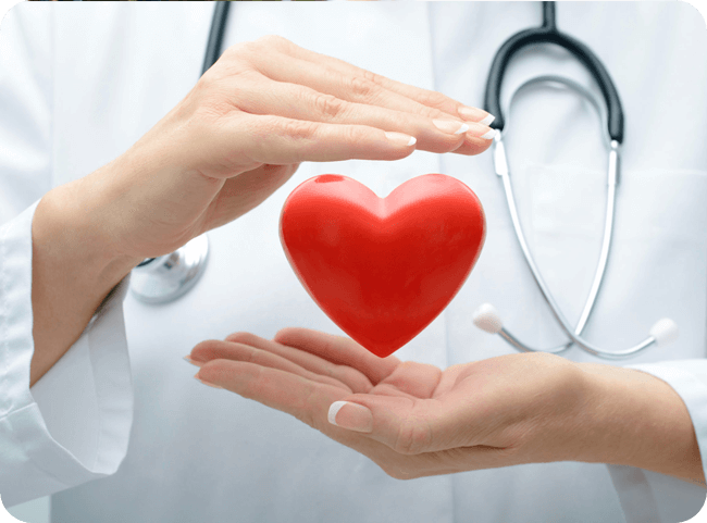 A healthcare professional cradles a red heart-shaped object between her hands, symbolizing care and compassion for patient health.
