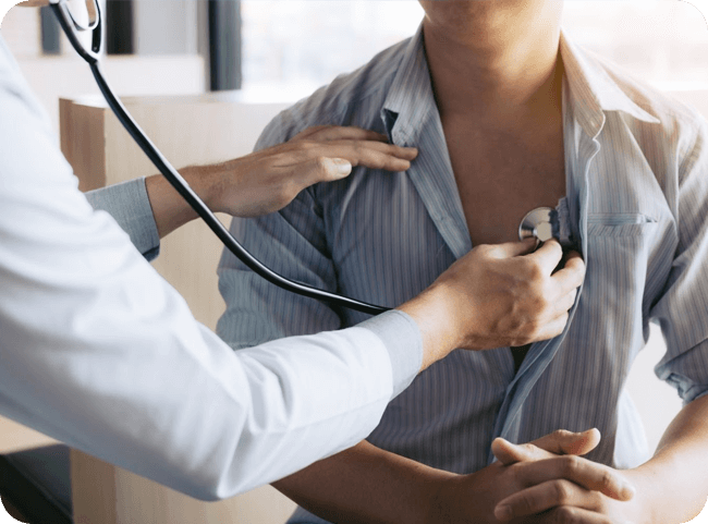 A healthcare professional uses a stethoscope to examine a patient’s heartbeat in a medical setting.